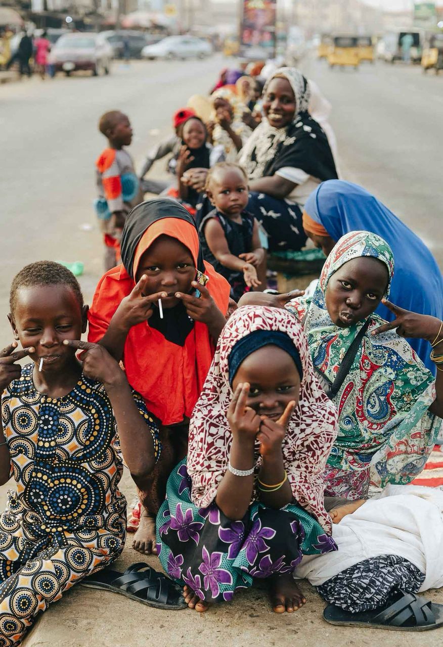 A group of children smiling and posing for the camera, embodying joy and hope through Hunger Relief West Africa’s efforts. Learn more about their stories on The Pulse of Hope blog