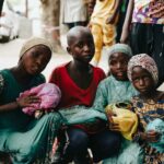 A group of children holding meals provided by Hunger Relief West Africa, representing nourishment and hope for the future