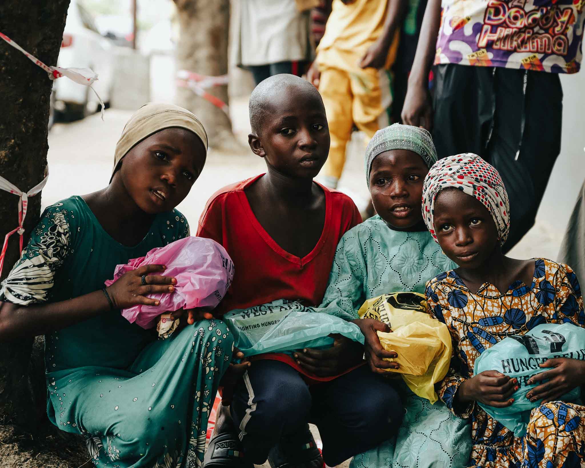 A group of children holding meals provided by Hunger Relief West Africa, representing nourishment and hope for the future